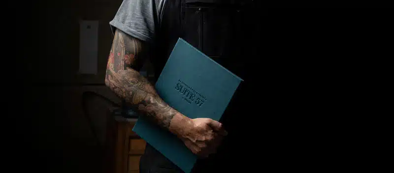 Cartas para restaurantes 3 Artesano del taller Kartia sosteniendo una carta de restaurante en polipiel azul