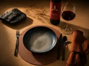 Recursos 1 Bajoplato personalizado de polipiel con logotipo grabado de Bodegas Portia en mesa de restaurante